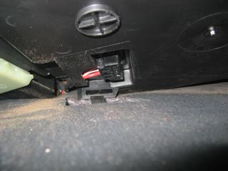 Plastic tab at front of lower dashboard cover.